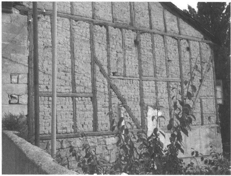 Брусовый дом в Бахчисарае. Отсутствие штукатурки позволяет видеть калыбное заполнение пространств между брусьями и массивный каменный цоколь здания. Фото автора